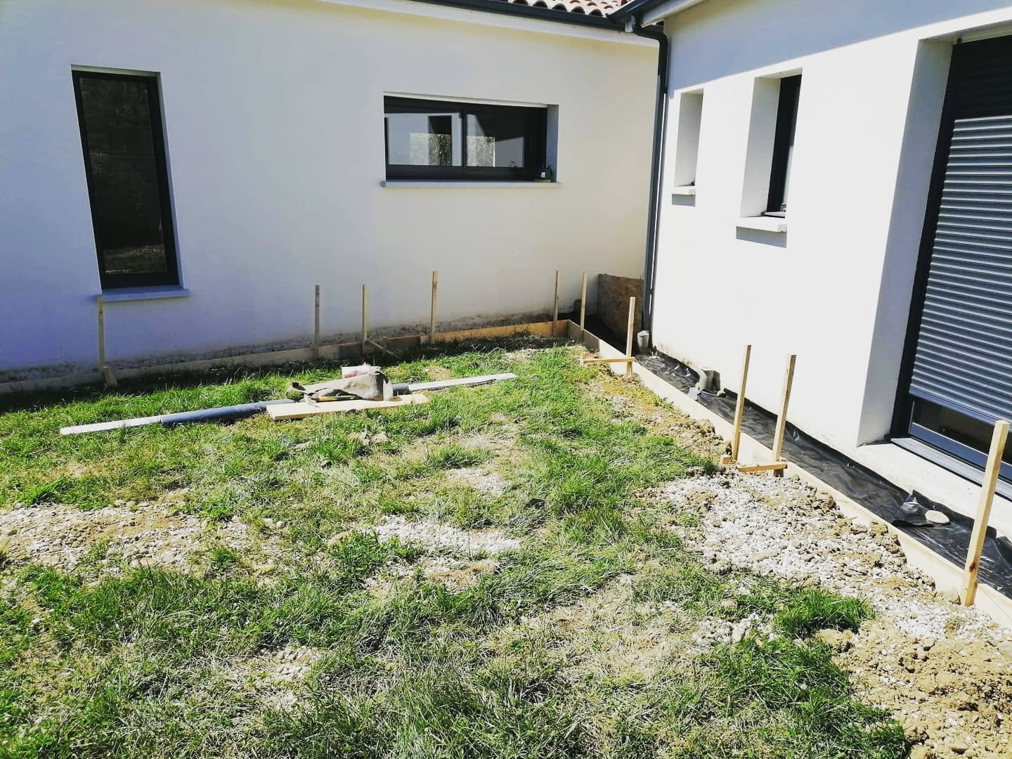 Coffrage en bois pour future terrasse devant une maison blanche en chantier.